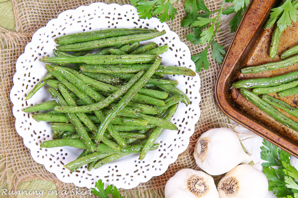 Roasted Green Beans with Garlic overhead shot showing green beans on a pan and a white plate.