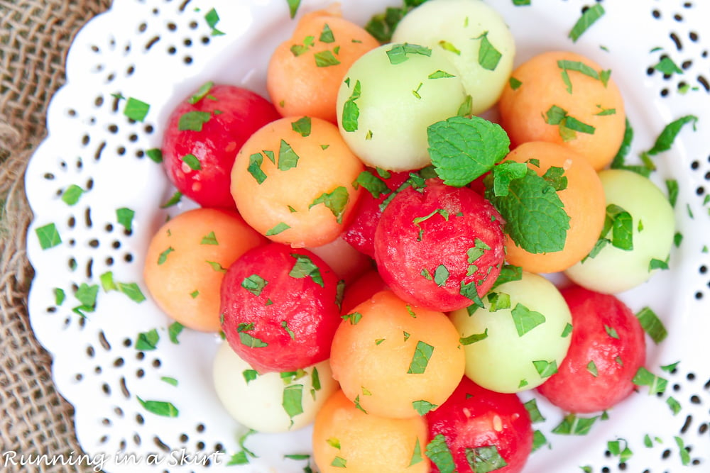 Honey Lime Melon Salad with mint on a white plate overhead shot.