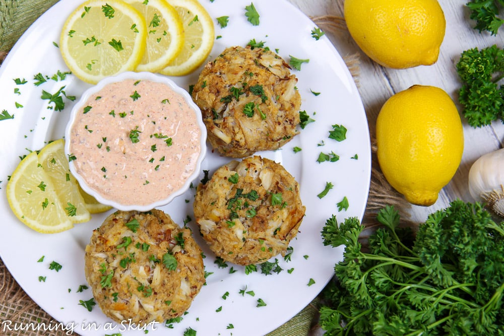 Broiled Crab Cakes on a white plate with remoulade sauce.