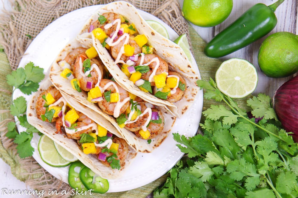 Overhead shot of blackened Shrimp Tacos with mango salsa with cilantro and lime on the side.
