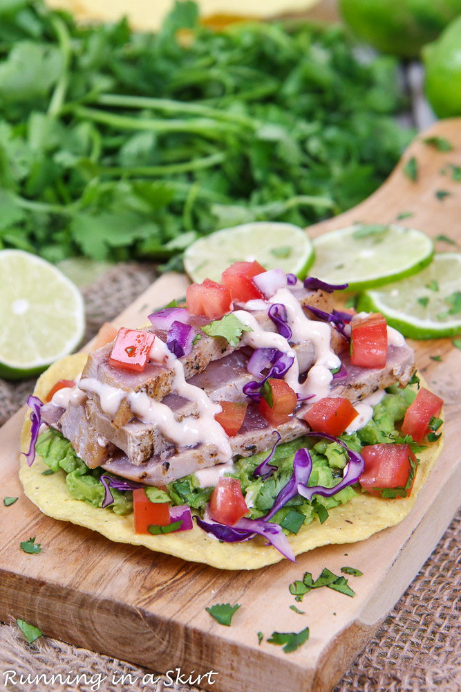 Ahi Tuna Tostada on a cutting board with cilantro and lime.