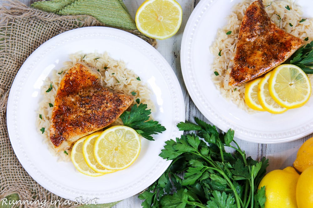 Blackened swordfish baked overhead shot on white plates with lemon.