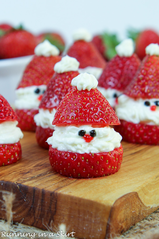 Strawberry Santas lined up on a serving board.