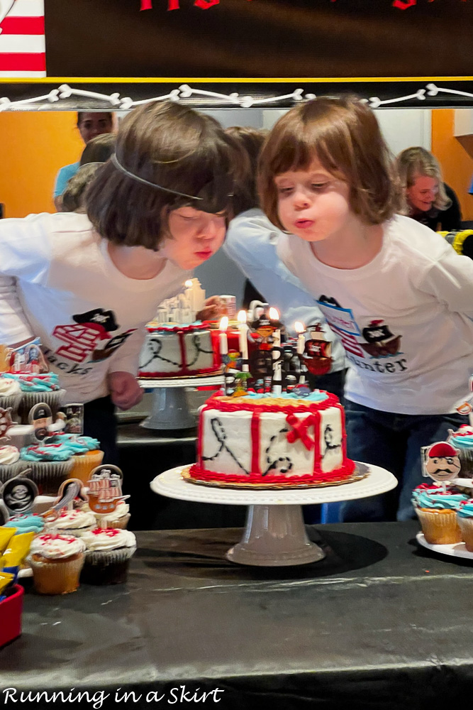 Kids blowing out candles on Pirate Birthday Party Cake