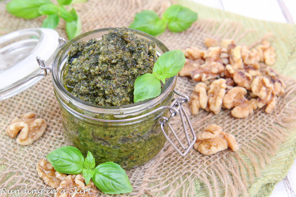 Walnut Pesto recipe in a glass jar with walnuts and basil.