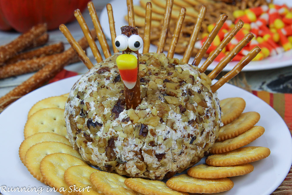 Turkey Cheese Ball for Thanksgiving on a white plate with crackers.