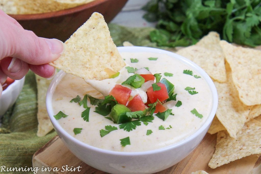 Cottage Cheese Queso Dip with chip going into bowl.