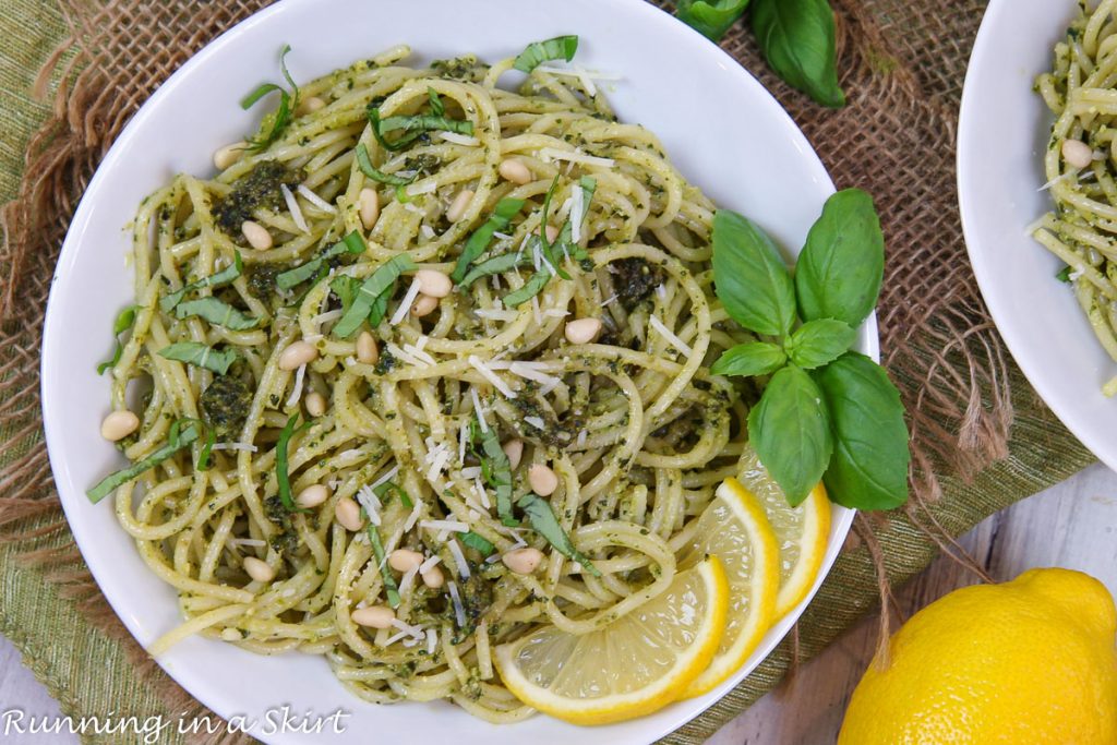 Lemon Pesto Pasta on a white plate with basil and lemons.