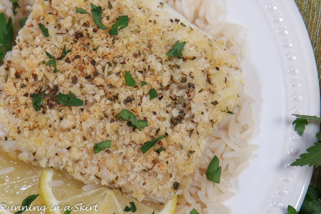 Parmesan Crusted Cod on a white plate with rice.